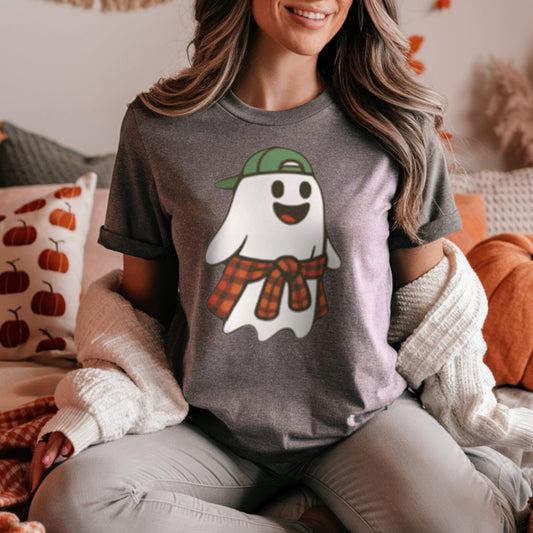 Woman wearing a t-shirt with a ghost graphic in a cozy room with pumpkins and fall decorations.