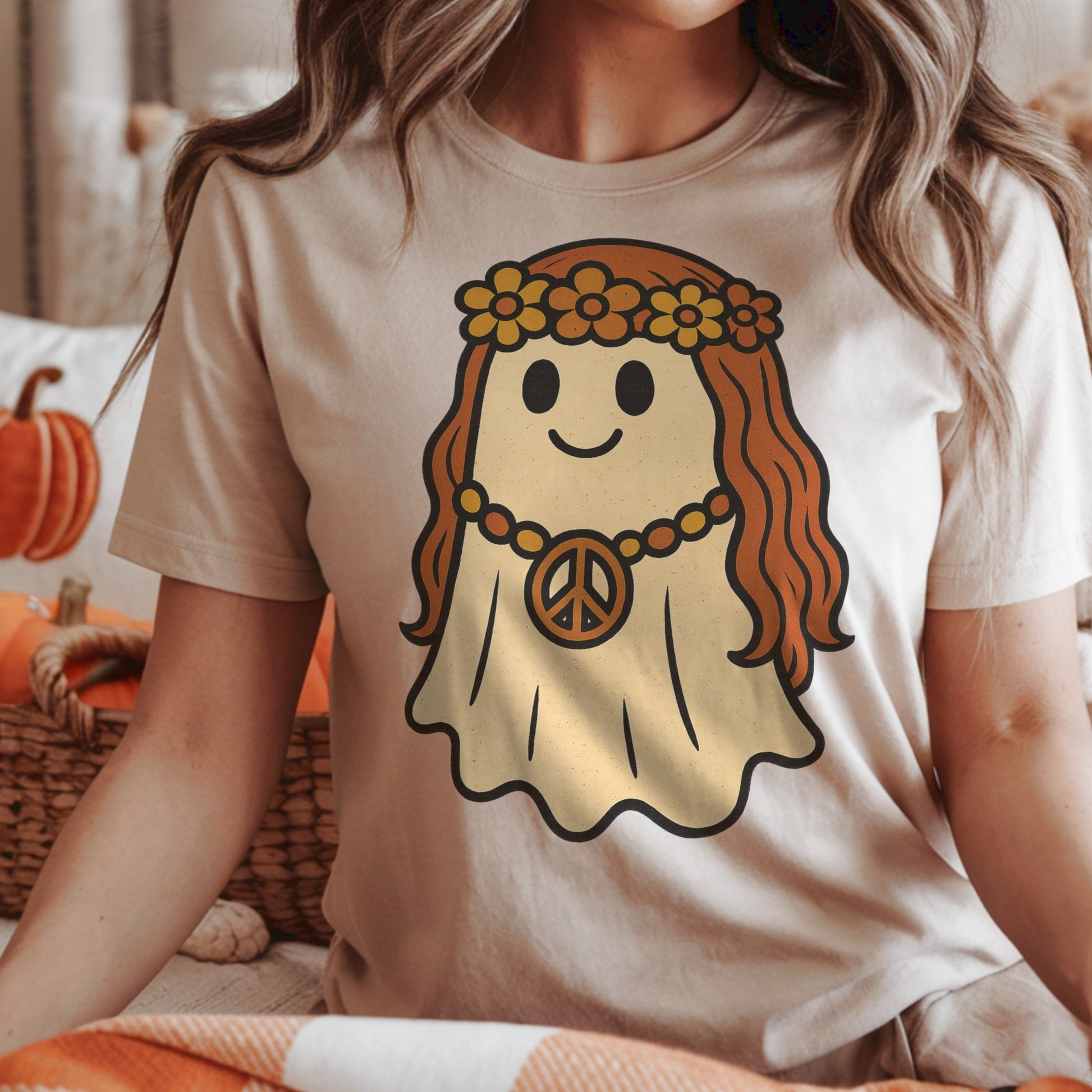 A person wearing a t-shirt in soft cream with a graphic of a retro 70s flower child ghost.