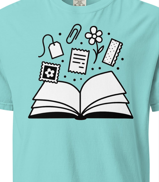Light blue t-shirt with an open book graphic and various icons on a white background