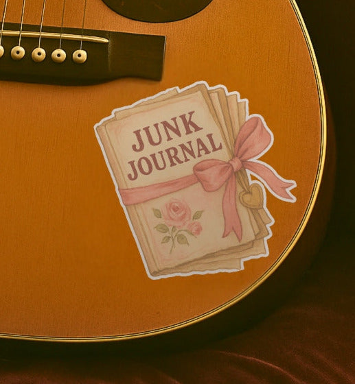 Guitar with a 'Junk Journal' sticker featuring a pink bow and roses on a brown background.