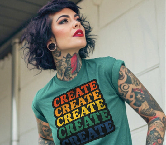 Person wearing a seafoam t-shirt with 'CREATE' in rainbow colors.