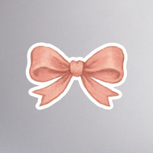 Pink coquette aesthetic bow sticker with white kiss cut border.